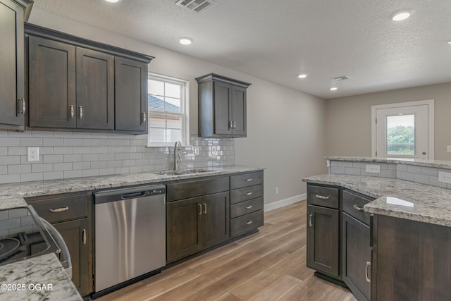 1220 Sheila Ann Dr, Carthage, MO 64836 - kitchen with dishwasher, light wood finished floors, backsplash, healthy amount of natural light, and a textured ceiling