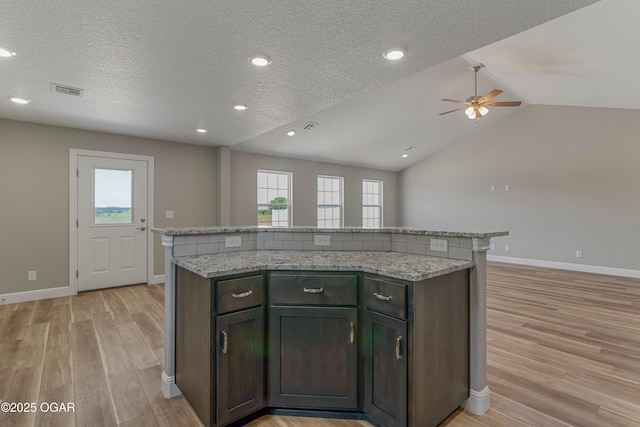 1220 Sheila Ann Dr, Carthage, MO 64836 - kitchen featuring a ceiling fan, light wood finished floors, a textured ceiling, vaulted ceiling, and a kitchen island