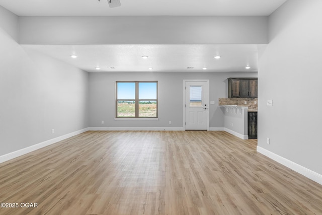 1224 Sheila Ann Dr, Carthage, MO 64836 - unfurnished living room with light wood-type flooring, recessed lighting, a glass covered fireplace, and a ceiling fan