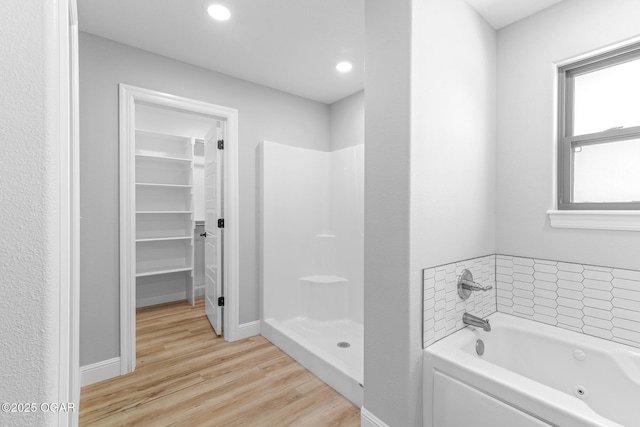 1224 Sheila Ann Dr, Carthage, MO 64836 - full bathroom with wood finished floors, a tub with jets, a spacious closet, a shower, and recessed lighting