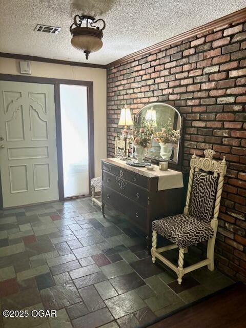 1606 Fairview Ave, Baxter Springs, KS 66713 - foyer entrance featuring a textured ceiling and brick wall