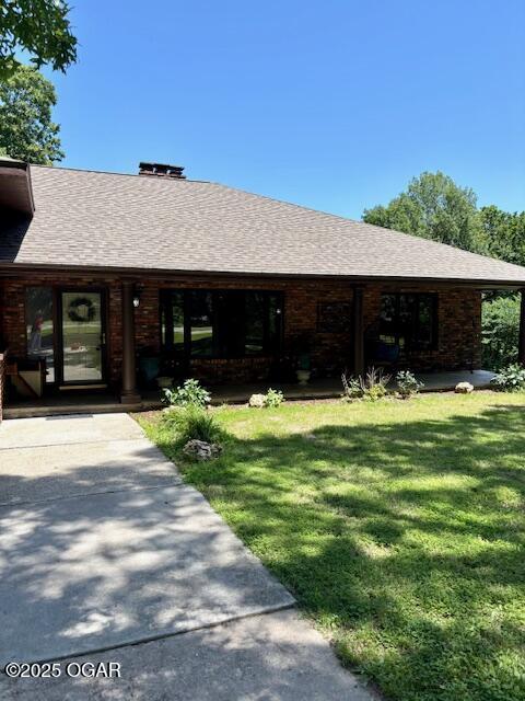 1606 Fairview Ave, Baxter Springs, KS 66713 - rear view of house featuring a yard