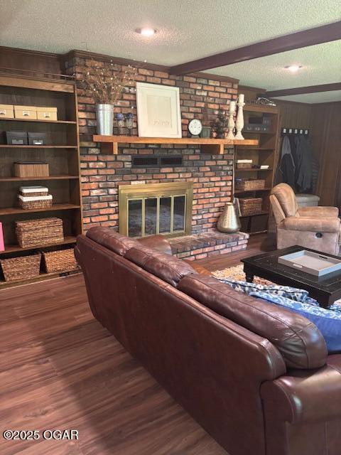 1606 Fairview Ave, Baxter Springs, KS 66713 - living area with a textured ceiling, wood finished floors, a fireplace, wooden walls, and beamed ceiling