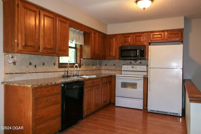 3619 Oak Ridge Dr, Joplin, MO 64804 - kitchen with white appliances, decorative backsplash, brown cabinets, light wood-type flooring, and a textured ceiling