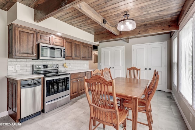 204 Split Rail Dr, Joplin, MO 64801 - kitchen with appliances with stainless steel finishes, a wooden ceiling with exposed beams, tasteful backsplash, light countertops, and brown cabinetry