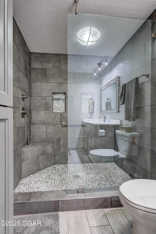 204 Split Rail Dr, Joplin, MO 64801 - bathroom with a textured ceiling, a tile shower, and tile walls