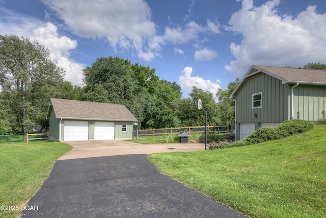 204 Split Rail Dr, Joplin, MO 64801 - view of home's exterior with board and batten siding, a detached garage, an outdoor structure, and a shingled roof