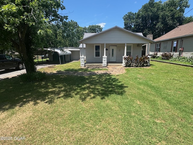 416 E 4th St, Baxter Springs, KS 66713 - view of front facade with a porch, a front lawn, and a detached carport
