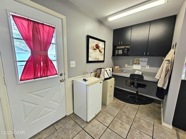 310 W 19th St, Baxter Springs, KS 66713 - laundry area with a textured ceiling, light tile patterned flooring, and an office area
