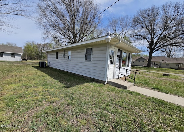 310 W 19th St, Baxter Springs, KS 66713 - view of property exterior featuring a central AC unit and a yard