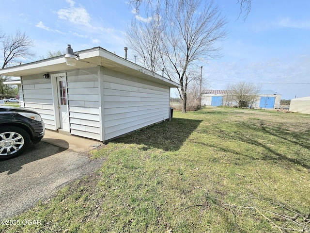310 W 19th St, Baxter Springs, KS 66713 - view of side of home with a lawn and an outbuilding