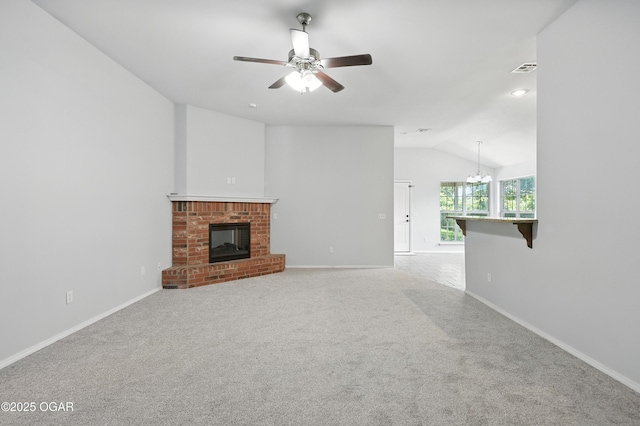 305 Anita Dr, Carl Junction, MO 64834 - unfurnished living room featuring vaulted ceiling, ceiling fan, a brick fireplace, carpet, and a chandelier