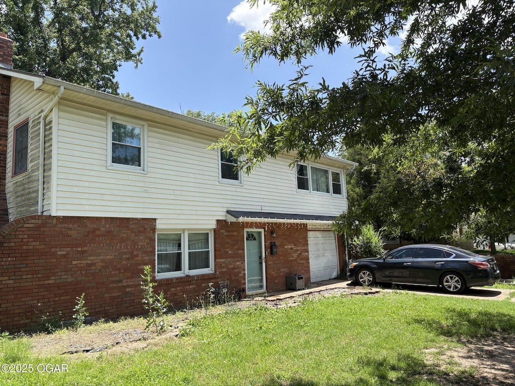 211 Par Ave, Webb City, MO 64870 - traditional-style home featuring a garage, a front yard, a chimney, brick siding, and driveway