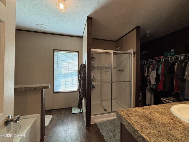 7575AND 7627 Amarillo Ln, Seneca, MO 64865 - full bathroom featuring a shower stall, wood finished floors, a textured ceiling, a garden tub, and vanity