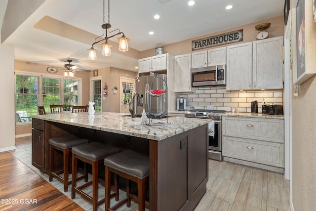 3101 Shore Dr, Grove, OK 74344 - kitchen with stainless steel appliances, decorative backsplash, recessed lighting, a kitchen island with sink, and a kitchen breakfast bar