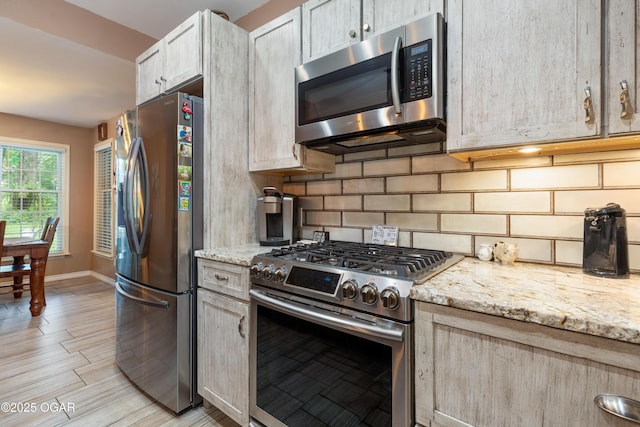 3101 Shore Dr, Grove, OK 74344 - kitchen featuring stainless steel appliances, tasteful backsplash, light stone counters, and light wood-style flooring