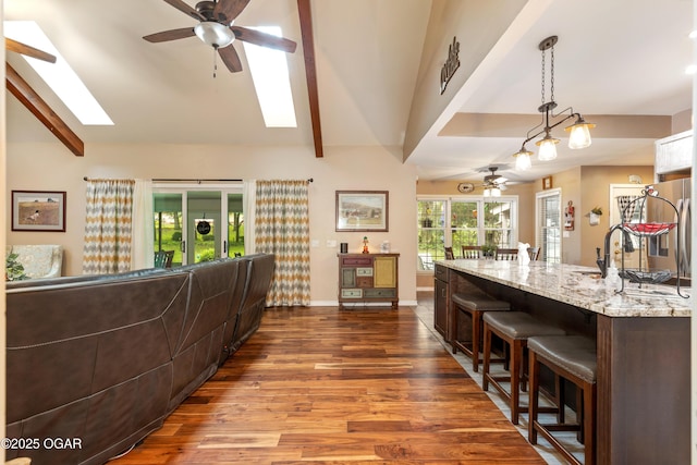 3101 Shore Dr, Grove, OK 74344 - kitchen featuring a ceiling fan, a skylight, wood finished floors, and a breakfast bar area
