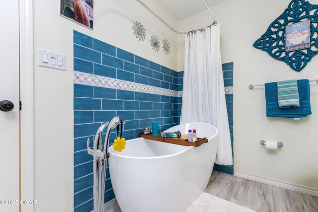 3101 Shore Dr, Grove, OK 74344 - full bathroom featuring a soaking tub, wood finished floors, tile walls, and a shower with curtain