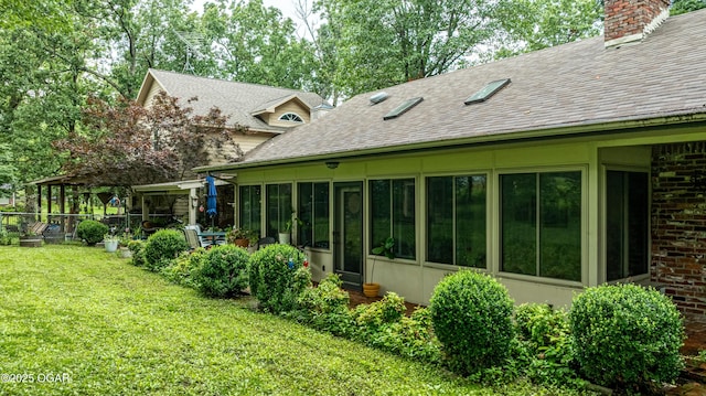 3101 Shore Dr, Grove, OK 74344 - back of property with a chimney, a sunroom, a lawn, and roof with shingles