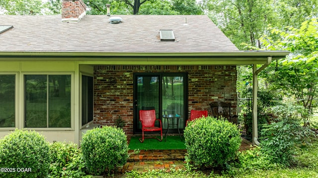 3101 Shore Dr, Grove, OK 74344 - property entrance featuring a shingled roof, a chimney, and brick siding