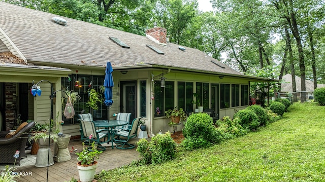 3101 Shore Dr, Grove, OK 74344 - rear view of property featuring a sunroom, roof with shingles, a yard, and a chimney