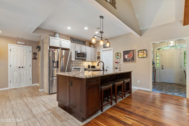 3101 Shore Dr, Grove, OK 74344 - kitchen with appliances with stainless steel finishes, light wood-style floors, a breakfast bar, recessed lighting, and an island with sink