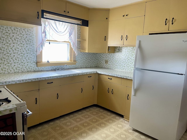 721 W Chestnut, Carthage, MO 64836 - kitchen featuring white appliances, light countertops, cream cabinets, decorative backsplash, and light floors