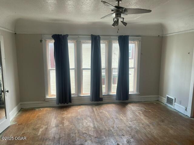 530 N Pearl Ave, Joplin, MO 64801 - empty room with hardwood / wood-style flooring, ceiling fan, a textured ceiling, and healthy amount of natural light