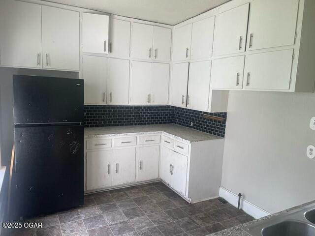 530 N Pearl Ave, Joplin, MO 64801 - kitchen featuring freestanding refrigerator, decorative backsplash, white cabinetry, and light countertops