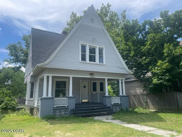 530 N Pearl Ave, Joplin, MO 64801 - view of front of home with a porch, a front yard, and a shingled roof