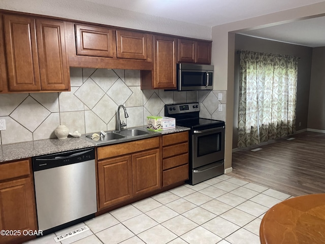 1701 S Kenser Rd, Joplin, MO 64801 - kitchen featuring appliances with stainless steel finishes, brown cabinets, and tasteful backsplash
