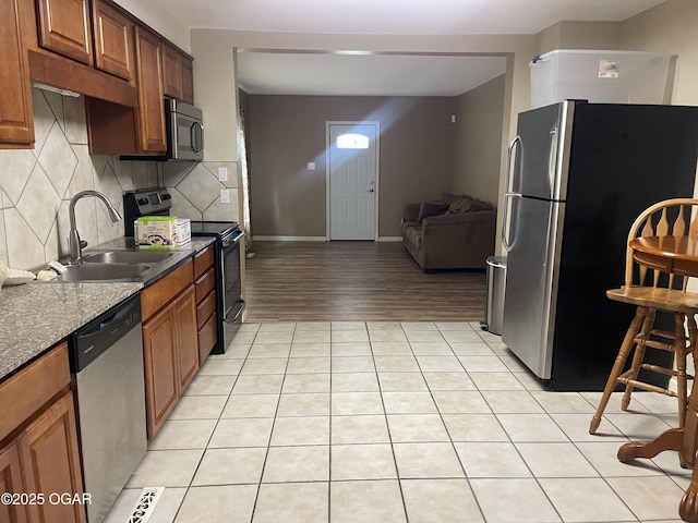1701 S Kenser Rd, Joplin, MO 64801 - kitchen with appliances with stainless steel finishes, decorative backsplash, open floor plan, light tile patterned floors, and dark countertops