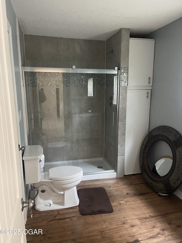 1701 S Kenser Rd, Joplin, MO 64801 - bathroom featuring wood finished floors, a shower stall, and a textured ceiling