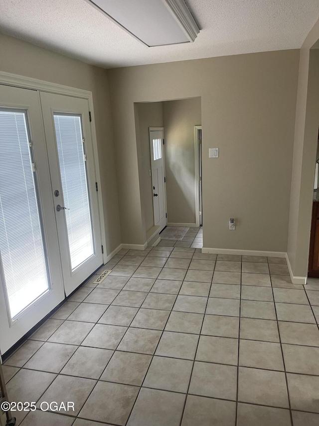 1701 S Kenser Rd, Joplin, MO 64801 - foyer entrance with light tile patterned flooring, french doors, and a textured ceiling