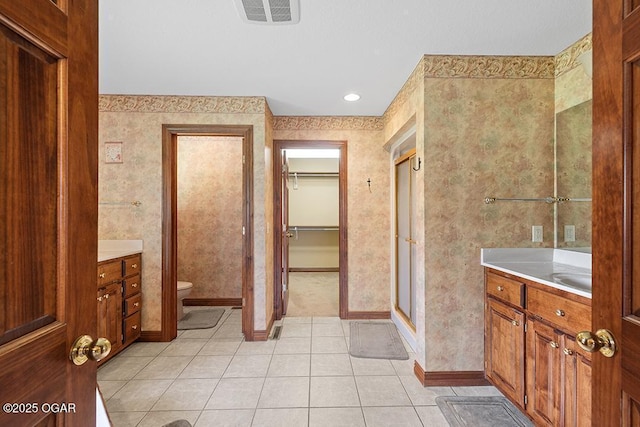 4345 Rob Ln, Joplin, MO 64804 - bathroom featuring vanity, tile patterned flooring, a spacious closet, a stall shower, and wallpapered walls