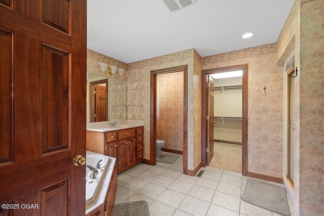 4345 Rob Ln, Joplin, MO 64804 - full bath featuring tile patterned floors, vanity, a garden tub, a walk in closet, and wallpapered walls