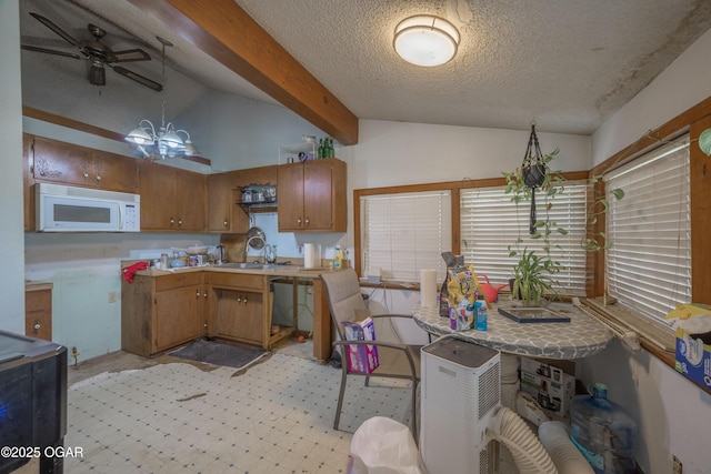 1021 Glendale Rd, Joplin, MO 64804 - kitchen with white microwave, brown cabinetry, light countertops, a ceiling fan, and a textured ceiling