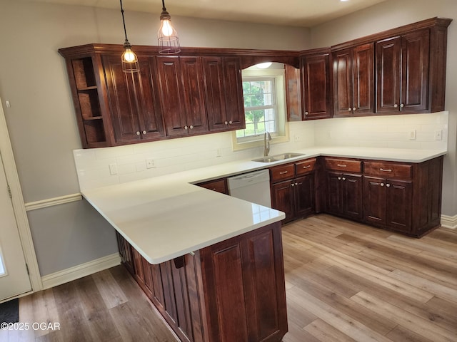 1502 E 7th St, Lamar, MO 64759 - kitchen featuring white dishwasher, light wood-type flooring, light countertops, a peninsula, and decorative backsplash