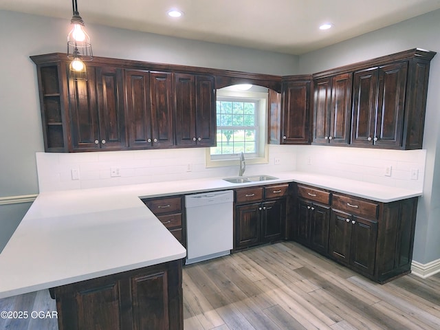 1502 E 7th St, Lamar, MO 64759 - kitchen featuring white dishwasher, light wood-style floors, light countertops, dark brown cabinetry, and backsplash
