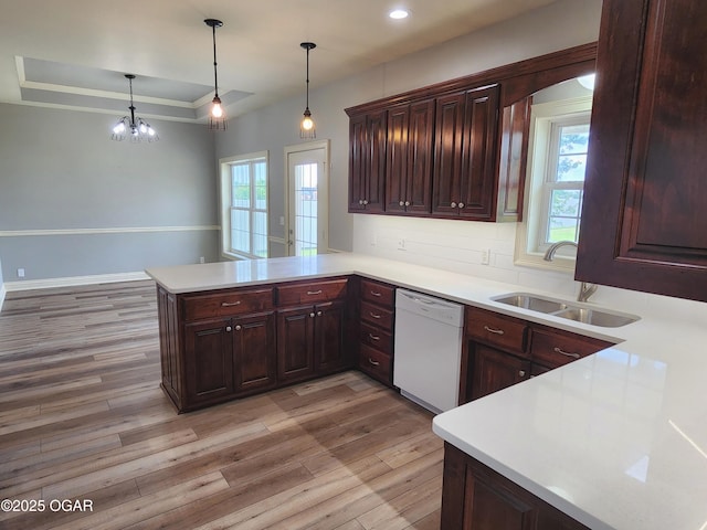1502 E 7th St, Lamar, MO 64759 - kitchen featuring white dishwasher, light wood-style flooring, a peninsula, light countertops, and a raised ceiling