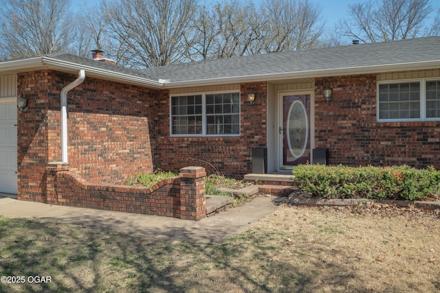 3701 College View Dr, Joplin, MO 64801 - doorway to property featuring brick siding, a garage, and roof with shingles