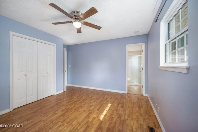3701 College View Dr, Joplin, MO 64801 - unfurnished bedroom with wood finished floors, a textured ceiling, a closet, a ceiling fan, and ensuite bath