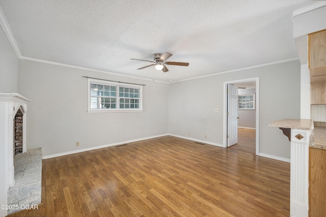 3701 College View Dr, Joplin, MO 64801 - unfurnished living room with ceiling fan, a fireplace, healthy amount of natural light, wood finished floors, and a textured ceiling