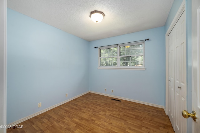 3701 College View Dr, Joplin, MO 64801 - unfurnished bedroom with wood finished floors, a closet, and a textured ceiling