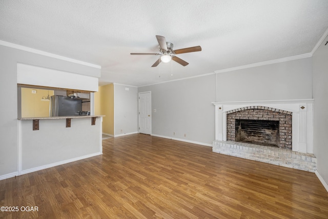 3701 College View Dr, Joplin, MO 64801 - unfurnished living room with wood finished floors, ceiling fan, a textured ceiling, a fireplace, and ornamental molding