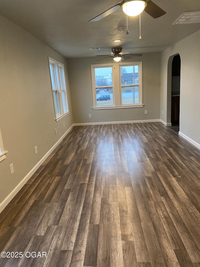 801 S Picher Ave, Joplin, MO 64801 - empty room with arched walkways, healthy amount of natural light, ceiling fan, and dark wood-type flooring