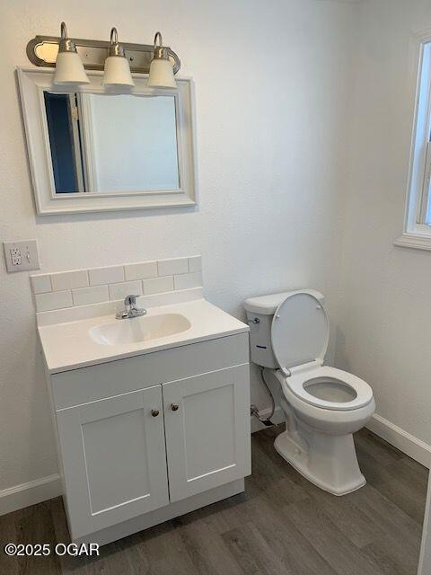 801 S Picher Ave, Joplin, MO 64801 - half bath with wood finished floors, vanity, and backsplash