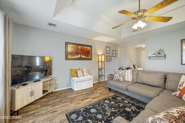 2238 Holly Ln, Miami, OK 74354 - living room featuring dark wood-style floors, a tray ceiling, and ceiling fan