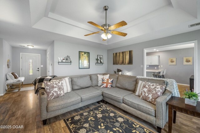 2238 Holly Ln, Miami, OK 74354 - living room featuring a raised ceiling, ceiling fan, and wood finished floors