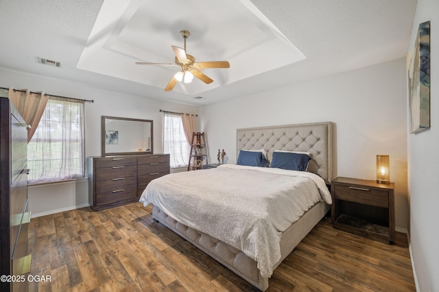 2238 Holly Ln, Miami, OK 74354 - bedroom featuring a raised ceiling, dark wood-type flooring, and ceiling fan